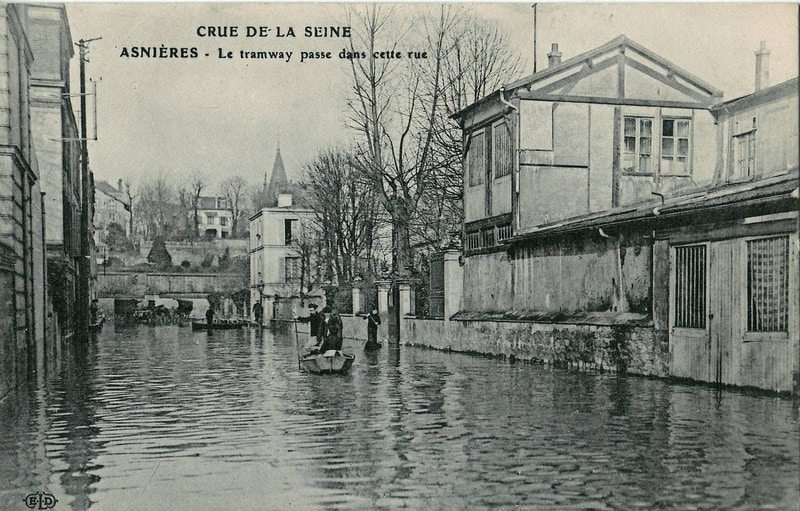 Old postcard showing what looks like a canal. Text reads CRUE DE LA SEINE. ASNIERES - Le tramway passe dans cette rue