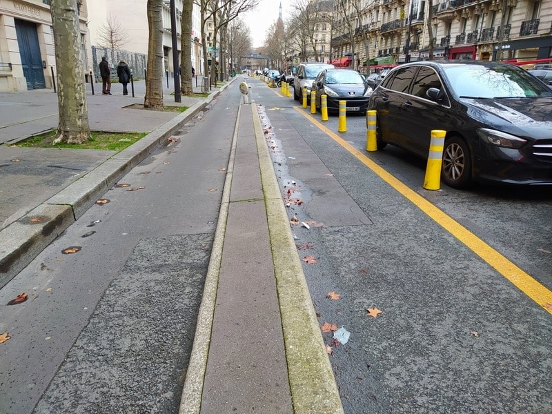 Two segregated cycle lanes, separated from each other by kerbstones and from car traffic by yellow temporary bollards