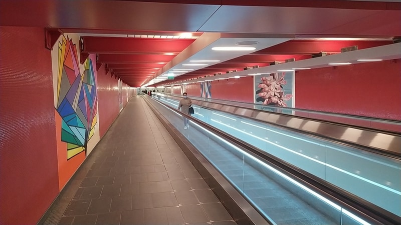 Long corridor with red walls and ceilings and two travelators