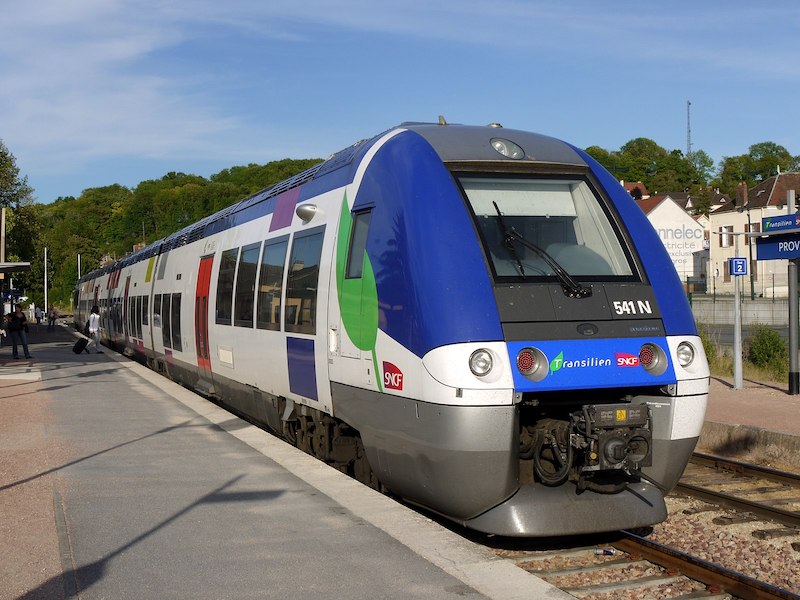 White, blue and red train labelled Transilien SNCF, on a platform