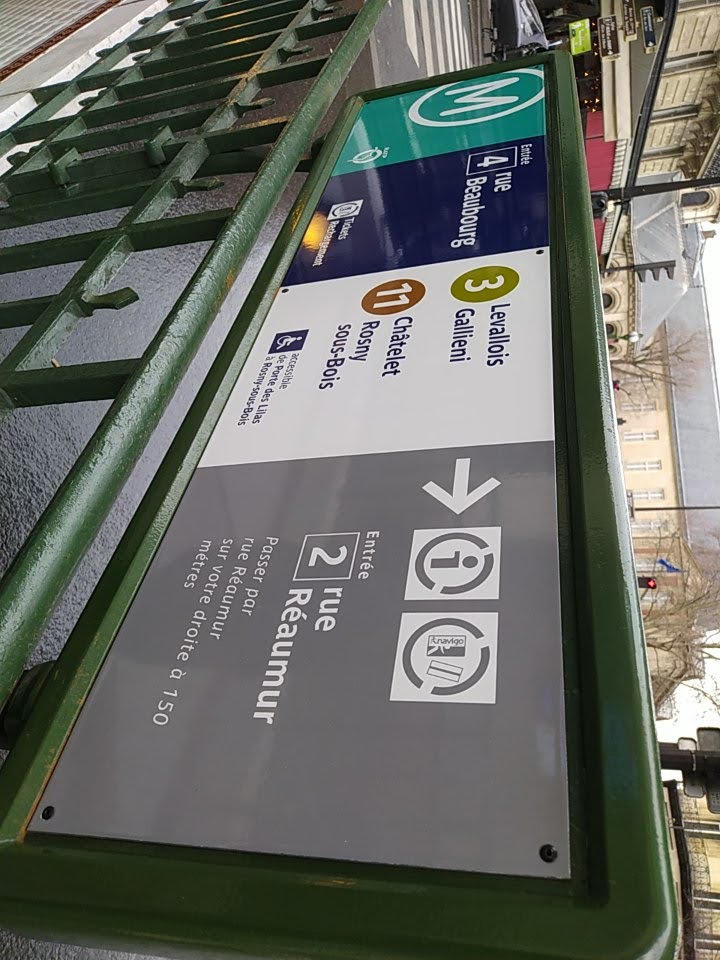 Sign at a metro entrance showing line 3 as running between Levallois and Galliéni, and line 11 between Châtelet and Rosny-sous-Bois. The sign also indicates that line 11 is wheelchair-accessible between Porte des Lilas and Rosny-sous-Bois