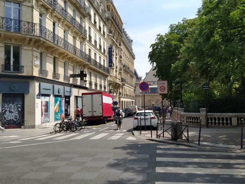 One-way street with contraflow cycle lane and “Zone 30” sign, running alongside a small park