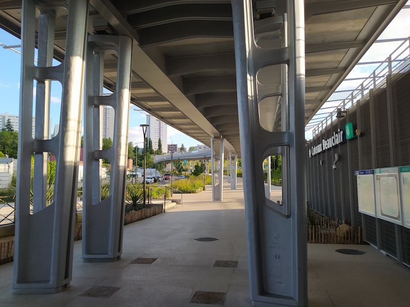 View from under the station, showing steel pillars, station information, and a view of the viaduct stretching away