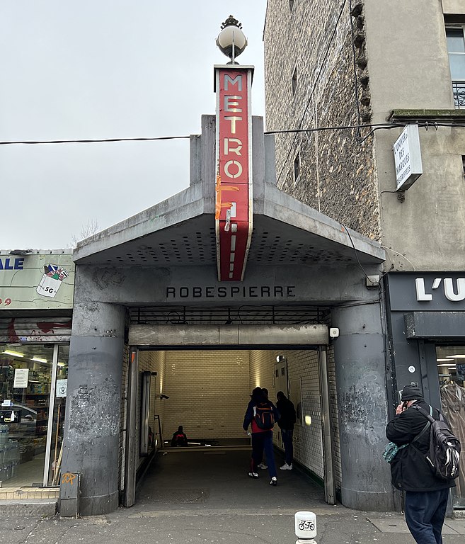 Art deco metro entrance with large red sign reading METRO and smaller lettering reading ROBESPIERRE