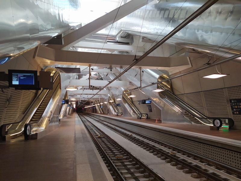 Looking down the platforms. Lots of escalators are visible