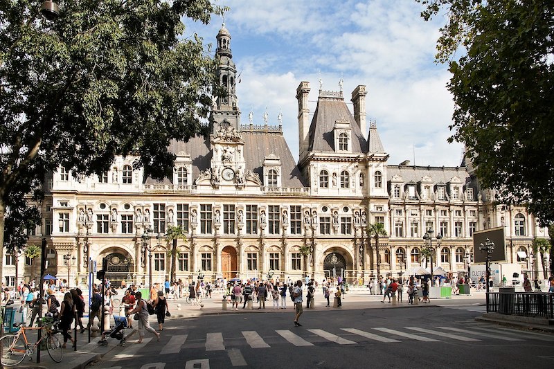 Grand municipal building with crowd in front