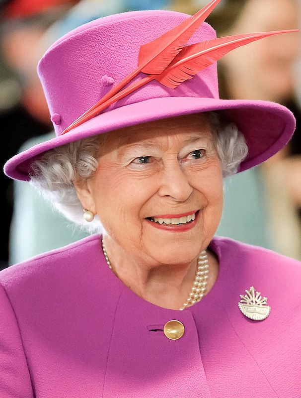 Queen Elizabeth II, dressed in pink and smiling