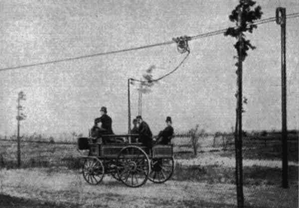 A carriage, resembling a horse-drawn vehicle, but connected by a slack wire to an overhead cable