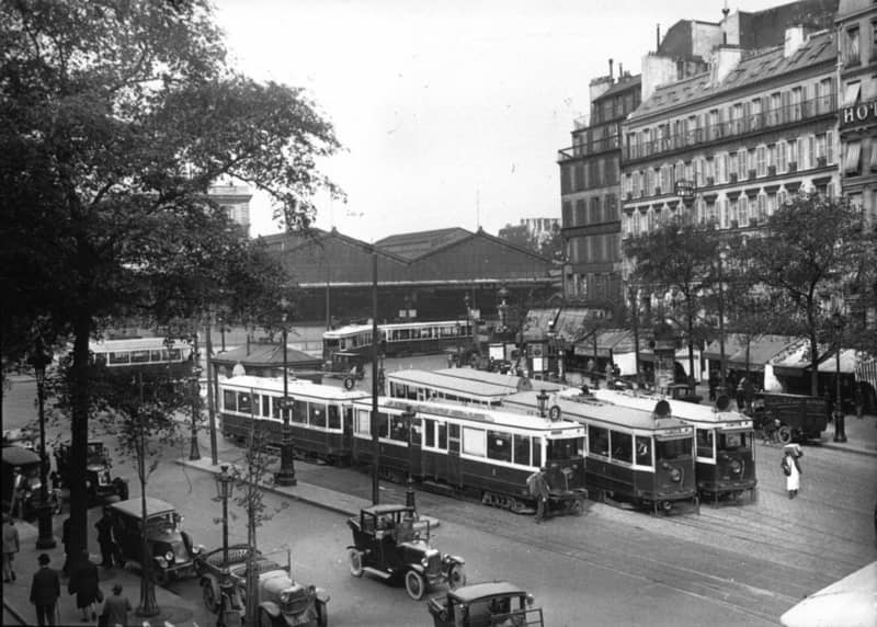 Five trams and multiple tracks outside a railway station