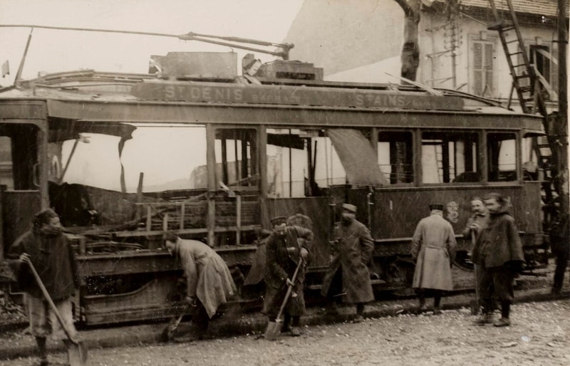 Ruins of a tram with people cleaning up
